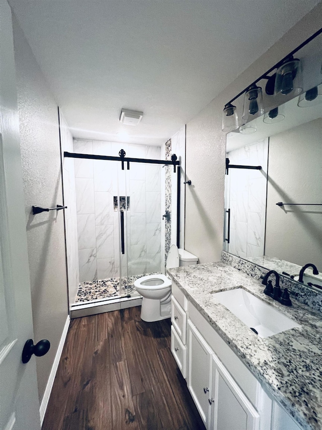 2411 Post Oak Ln, Groves, TX 77619 - bathroom with wood finished floors, vanity, a marble finish shower, and a textured wall
