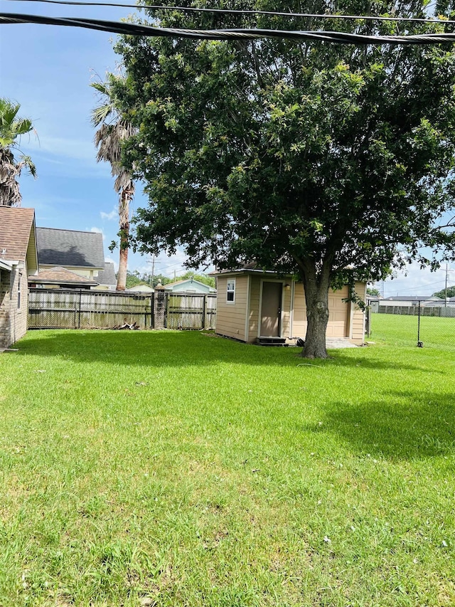 2411 Post Oak Ln, Groves, TX 77619 - fenced backyard featuring an outdoor structure