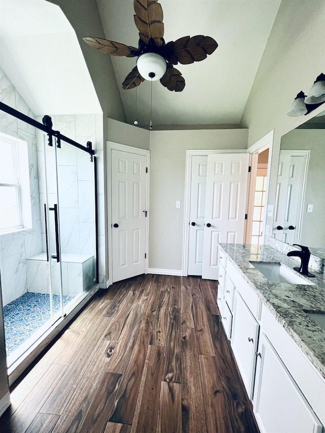 2411 Post Oak Ln, Groves, TX 77619 - bathroom featuring lofted ceiling, vanity, wood finished floors, a marble finish shower, and ceiling fan