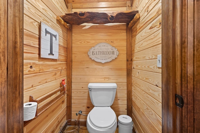 bathroom with wooden walls and toilet