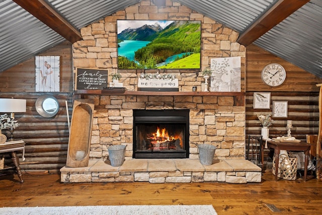 unfurnished living room featuring hardwood / wood-style floors, log walls, a stone fireplace, and beamed ceiling