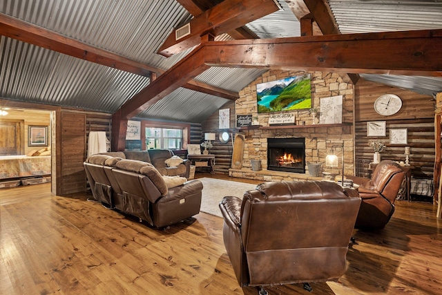 living area featuring wood-type flooring, vaulted ceiling with beams, and a fireplace