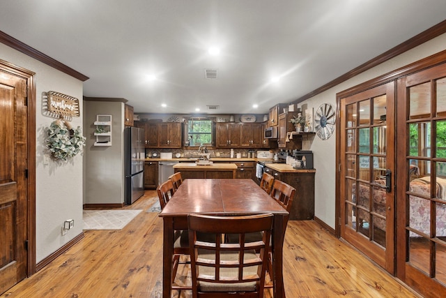 dining space featuring crown molding, light wood-style floors, french doors, baseboards, and recessed lighting