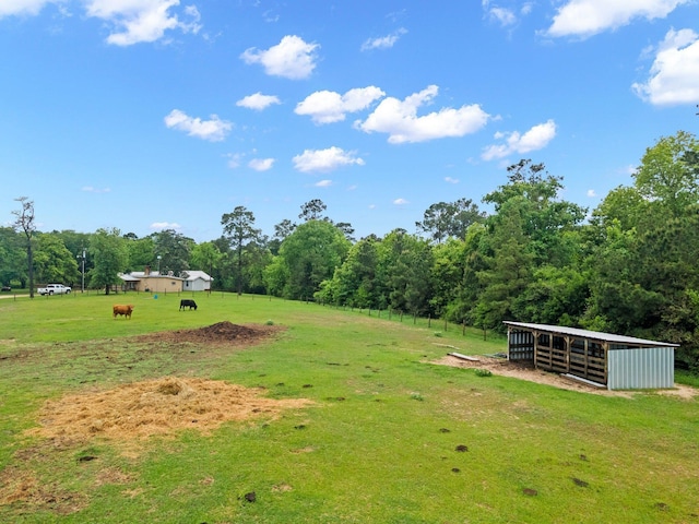 view of yard featuring an exterior structure, an outbuilding, a rural view, and a pole building