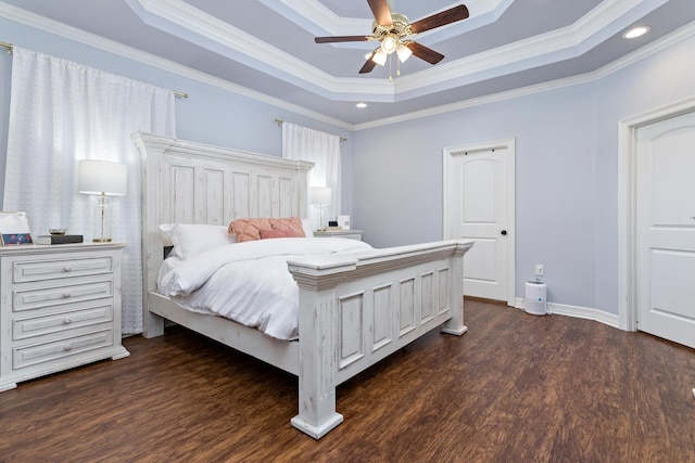 bedroom featuring dark hardwood / wood-style flooring, a tray ceiling, ceiling fan, and crown molding