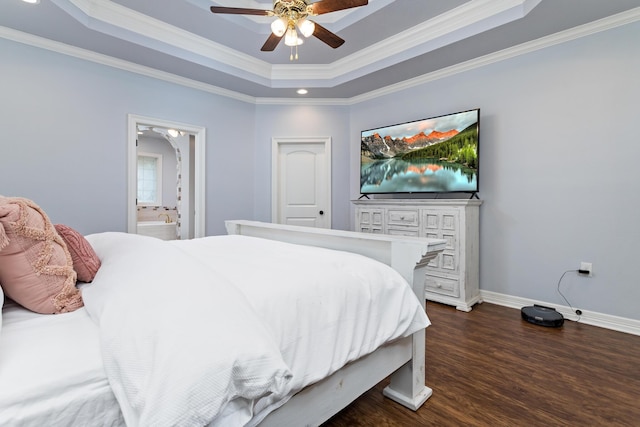 bedroom with dark hardwood / wood-style flooring, a raised ceiling, ceiling fan, crown molding, and connected bathroom