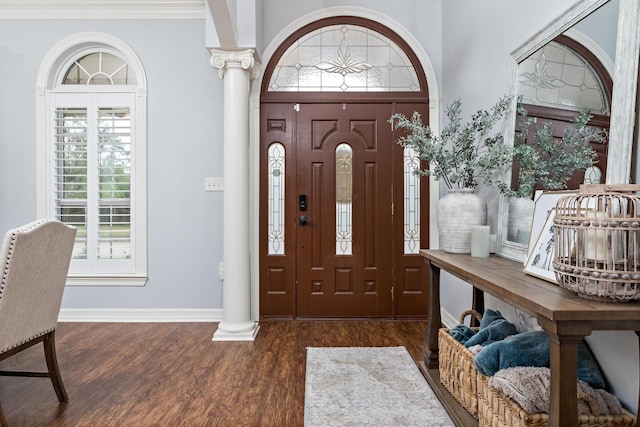 foyer featuring decorative columns, a wealth of natural light, and dark hardwood / wood-style flooring