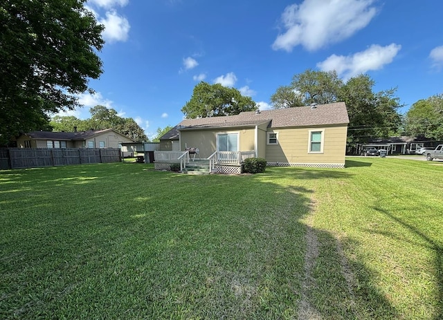 back of house with a lawn, a deck, and fence