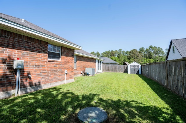 view of yard featuring central air condition unit, a fenced backyard, a storage unit, and an outdoor structure