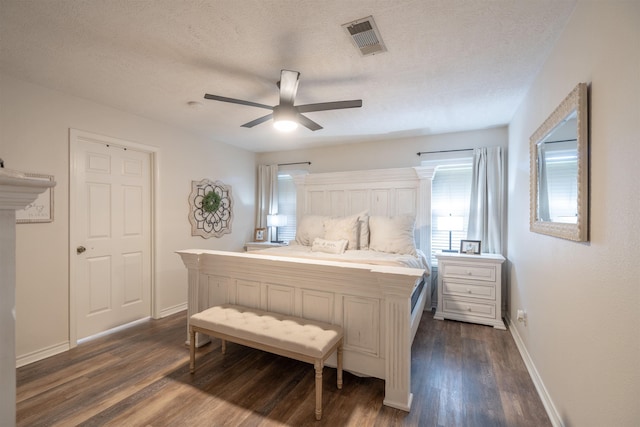 bedroom featuring baseboards, a textured ceiling, a ceiling fan, visible vents, and dark wood finished floors
