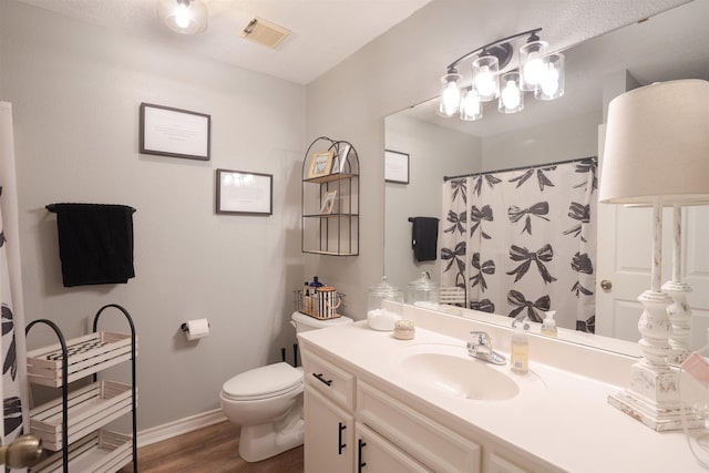 full bath featuring visible vents, baseboards, toilet, vanity, and wood finished floors
