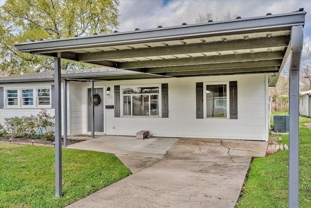 rear view of property with a patio area, central AC unit, and a yard