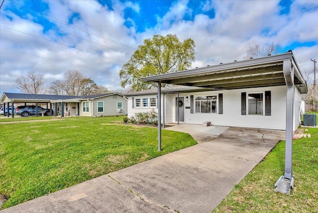 ranch-style home with central AC unit, concrete block siding, and a front yard