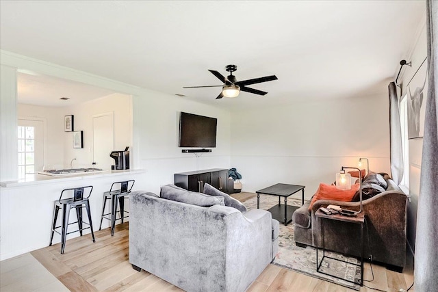 living area featuring light wood finished floors and ceiling fan