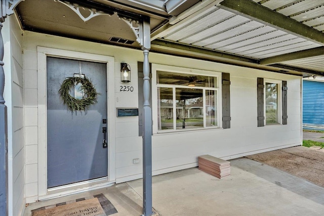 entrance to property featuring covered porch and concrete block siding