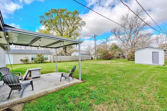 view of yard with a patio area, a shed, an outbuilding, and fence