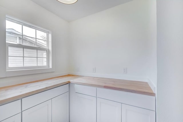 kitchen featuring white cabinets and wood counters