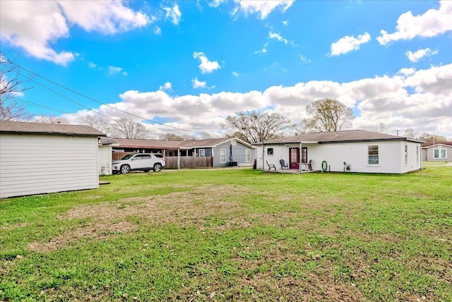 rear view of property with a lawn and a carport