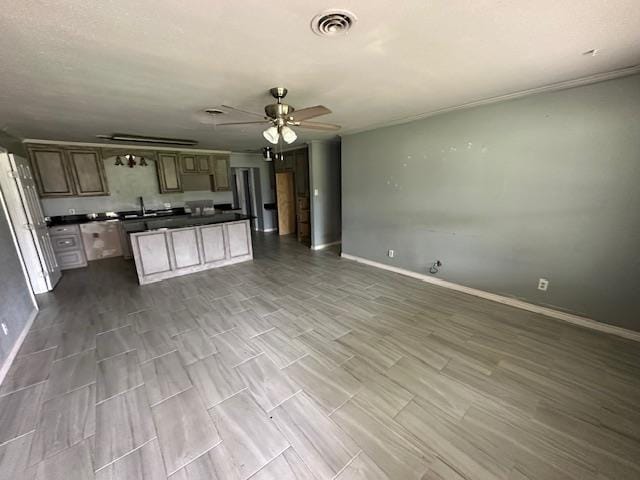kitchen featuring open floor plan, a sink, dark countertops, visible vents, and a ceiling fan