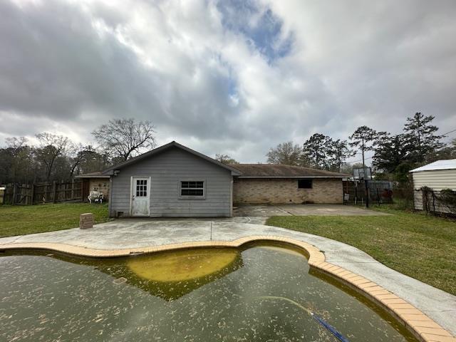 rear view of property with a lawn, fence, and a patio area