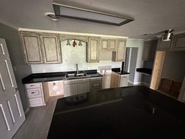 kitchen with crown molding, a sink, wood finished floors, dishwasher, and visible vents