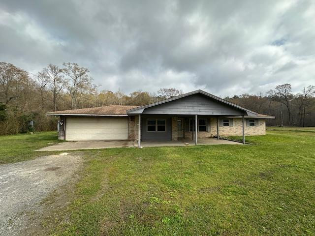 view of front of property with driveway, a front yard, and an attached garage
