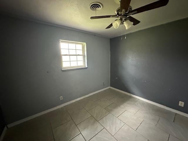 unfurnished room with baseboards, visible vents, ceiling fan, and light tile patterned floors