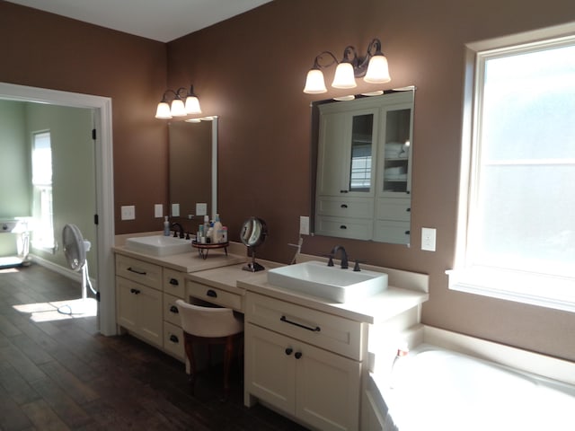 bathroom featuring vanity, a bath, and wood finished floors