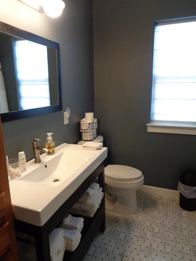 bathroom with toilet, vanity, and baseboards