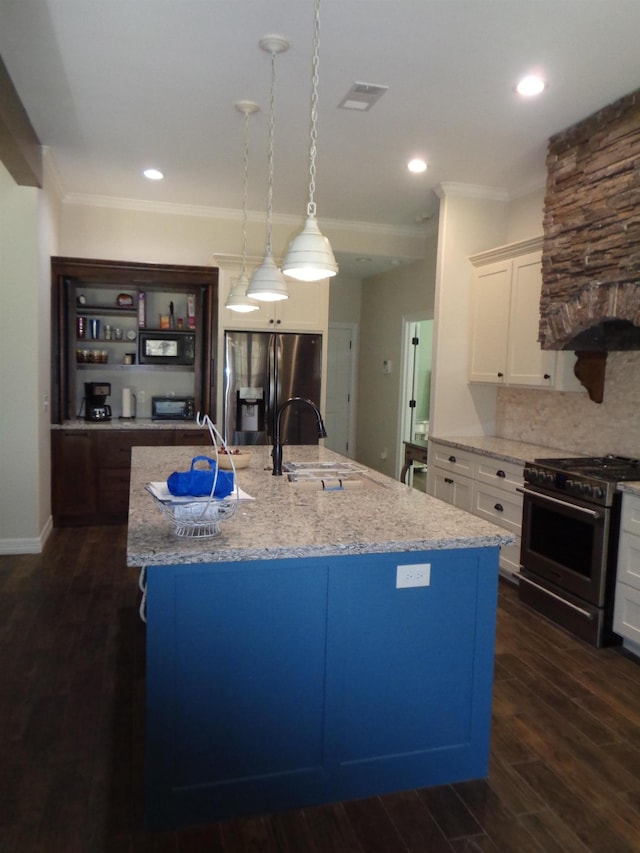 kitchen with a sink, crown molding, dark wood-style flooring, appliances with stainless steel finishes, and a kitchen island with sink