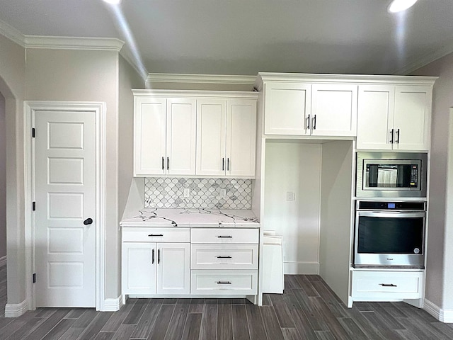 kitchen featuring decorative backsplash, white cabinetry, and appliances with stainless steel finishes