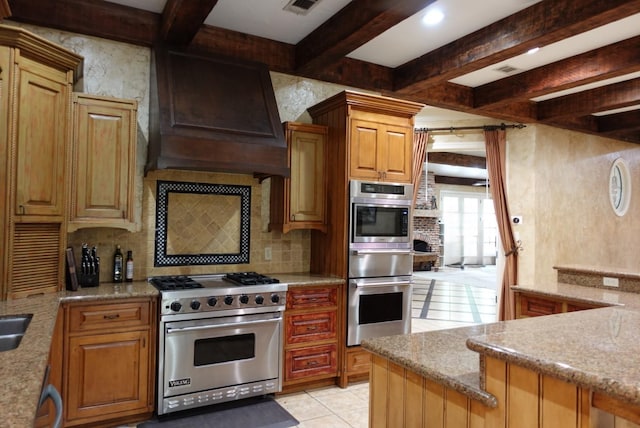 7840 Halliday St, Beaumont, TX 77706 - kitchen featuring appliances with stainless steel finishes, decorative backsplash, beam ceiling, light stone counters, and premium range hood