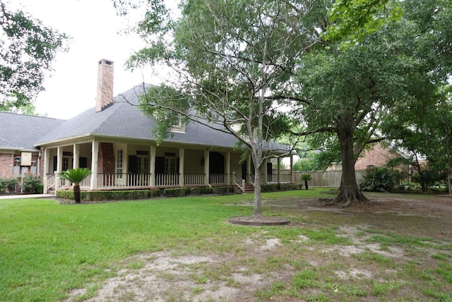 7840 Halliday St, Beaumont, TX 77706 - view of front facade with covered porch, a chimney, a front yard, and a shingled roof