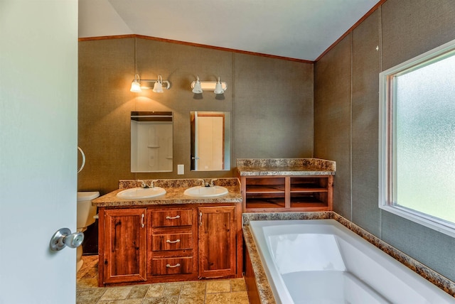bathroom featuring vaulted ceiling, a tub, vanity, toilet, and crown molding