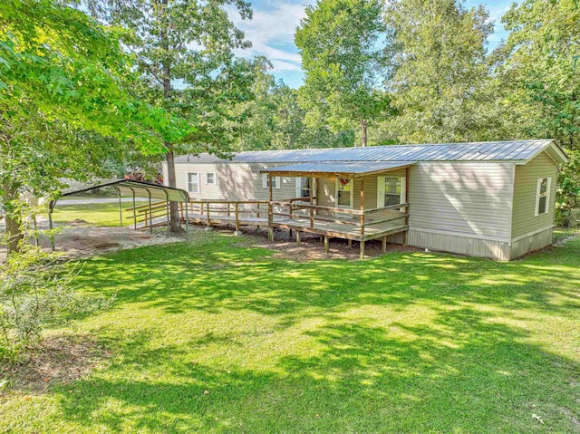 rear view of house featuring a lawn, a carport, and a deck