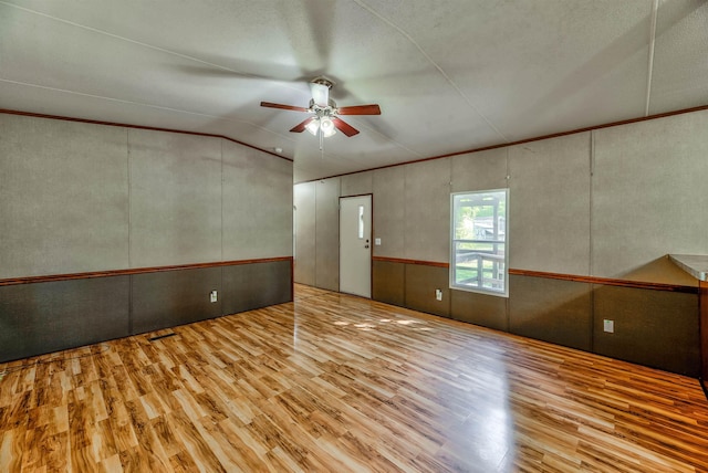 unfurnished room featuring lofted ceiling, crown molding, ceiling fan, and light wood-type flooring