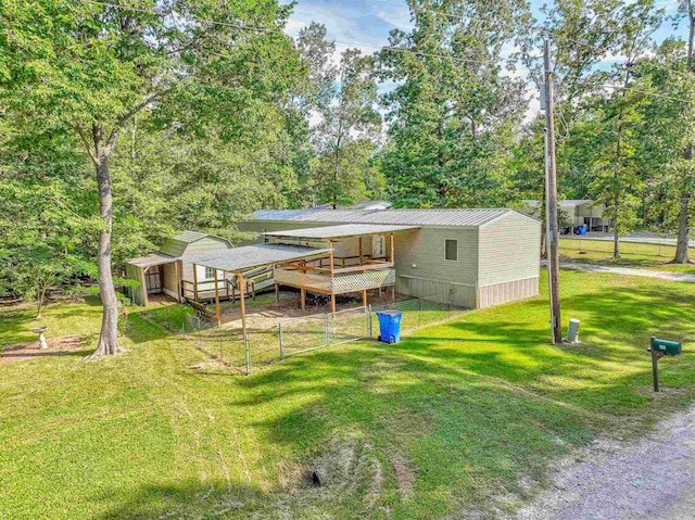 back of property featuring a wooden deck, a yard, and a carport