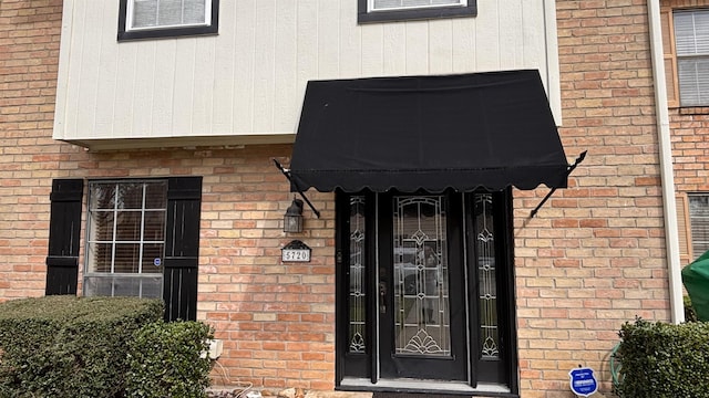 property entrance featuring brick siding