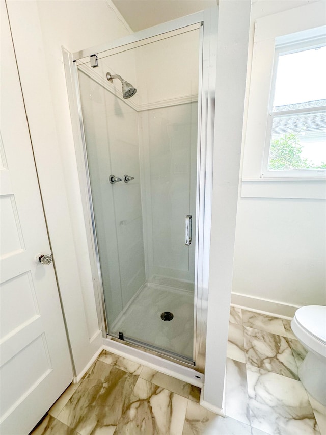 bathroom featuring toilet and an enclosed shower