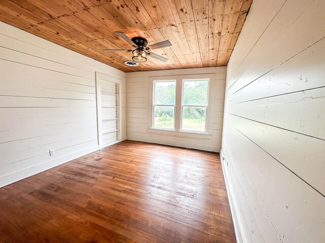 empty room with light hardwood / wood-style floors, ceiling fan, wood walls, and wood ceiling