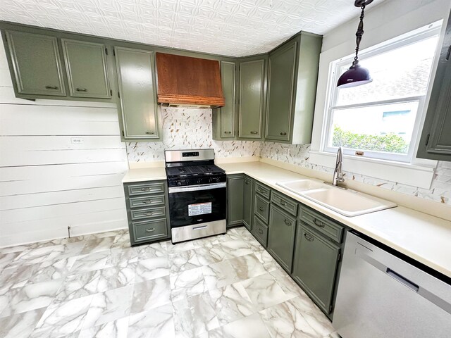 kitchen with green cabinets, sink, stainless steel appliances, and hanging light fixtures