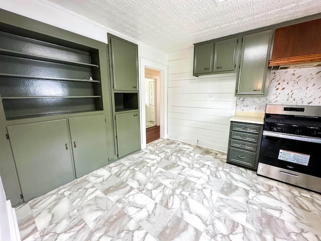 kitchen with built in shelves, wooden walls, stainless steel range, and green cabinetry