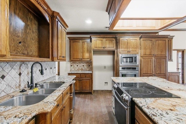 kitchen with dark wood-type flooring, light stone counters, sink, and stainless steel appliances