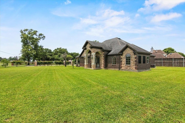 rear view of property with a yard and central AC