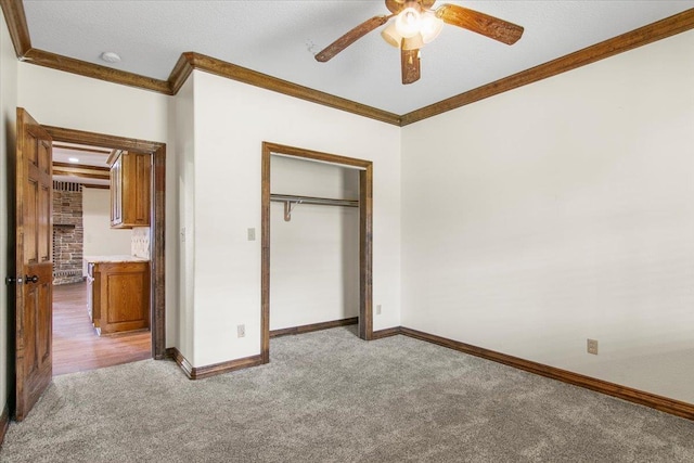 unfurnished bedroom with a closet, ceiling fan, crown molding, and light colored carpet