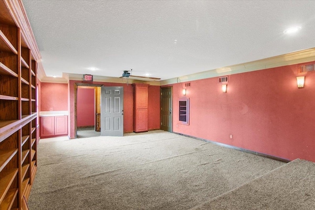 carpeted empty room with crown molding and a textured ceiling