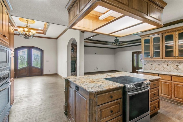 kitchen with backsplash, crown molding, hardwood / wood-style floors, and stainless steel appliances