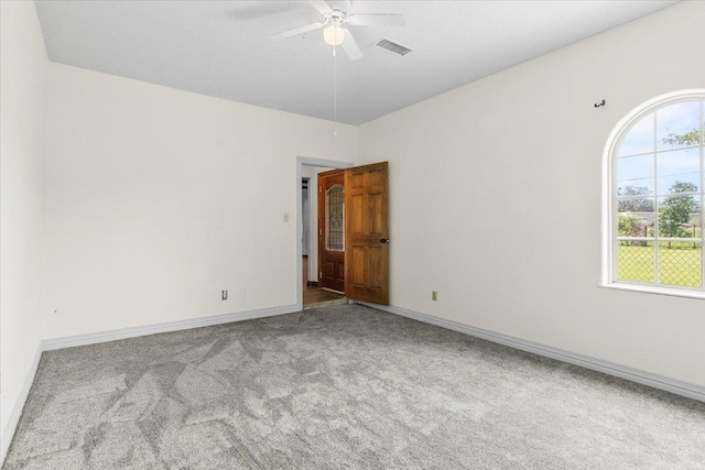 carpeted spare room featuring ceiling fan