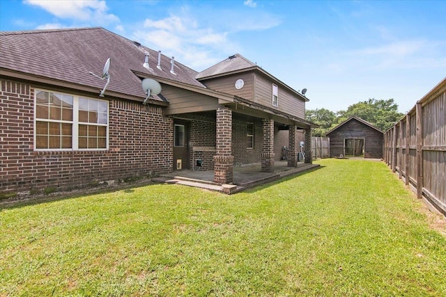 rear view of house featuring a lawn and a patio