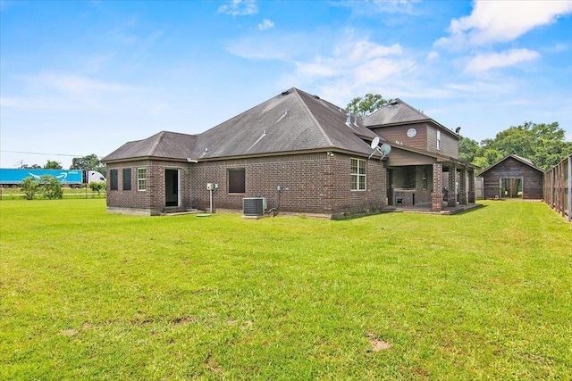 back of property featuring a patio area, a yard, and central AC